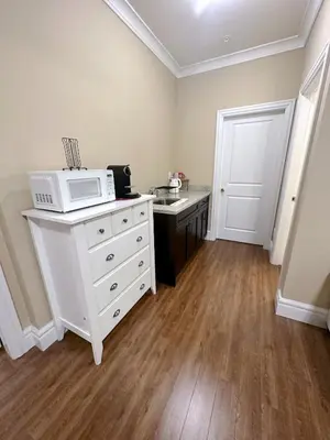 a kitchen with a microwave on a white dresser at Moon rooms in Vancouver