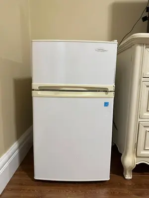 a white refrigerator in the corner of a room at Moon rooms in Vancouver