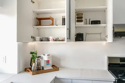 a kitchen with white walls and white cabinets at Modern Vancouver Private Room-15 Mins to Downtown in Vancouver