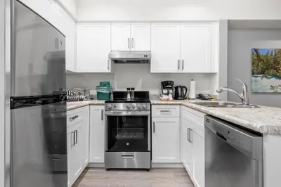 a kitchen with white cabinets and a stove top oven at Ski-in and Out Lake Placid Lodge in Whistler