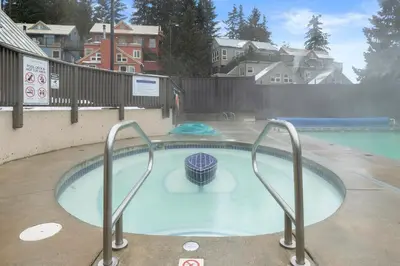 a hot tub in a swimming pool with metal rails at Ski-in and Out Lake Placid Lodge in Whistler