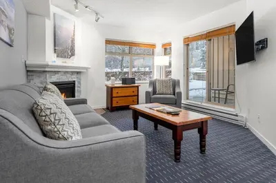 a living room with a couch and a table at Ski-in and Out Lake Placid Lodge in Whistler