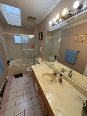 a bathroom with a sink and a tub and a mirror at Surrey-Delta Urban Stay - Walk to Transit & Shopping in Surrey
