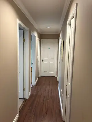 an empty hallway with white walls and wood floors at Surrey-Delta Urban Stay - Walk to Transit & Shopping in Surrey