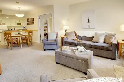 a living room with a couch and a table at Heart of Whistler Village, Mountain Views, Pool & Hot Tub in Whistler