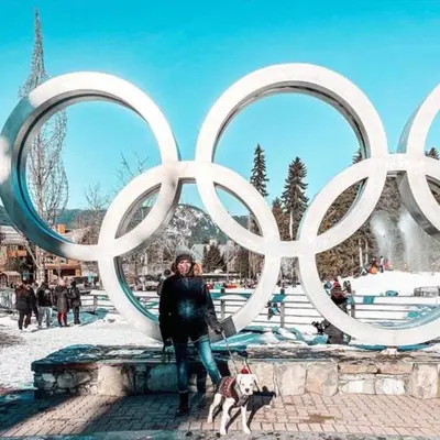 a woman with a dog standing in front of a sculpture at Heart of Whistler Village, Mountain Views, Pool & Hot Tub in Whistler