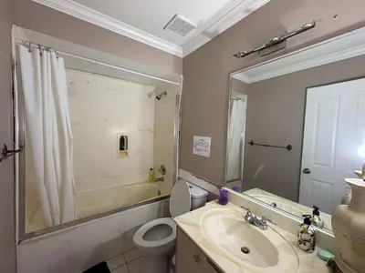 a bathroom with a sink and a toilet and a mirror at Nordel Way Guest House - Walk to Transit & Shopping - 20 Min to YVR in Surrey