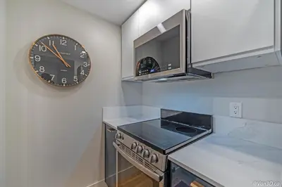 a clock on a wall above a stove in a kitchen at Beautiful Downtown Studio with Parking in Vancouver