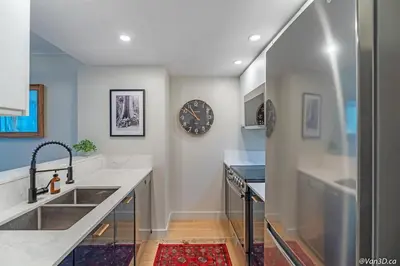 a kitchen with a sink and a clock on the wall at Beautiful Downtown Studio with Parking in Vancouver