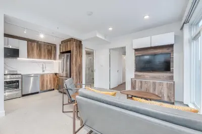 a kitchen and living room with a couch and a table at Upscale 1BR2BA Walk Everywhere in Vancouver