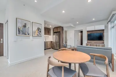 a living room with a table and chairs and a couch at Upscale 1BR2BA Walk Everywhere in Vancouver