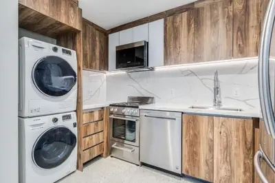 a kitchen with white appliances and wooden cabinets at Upscale 1BR2BA Walk Everywhere in Vancouver