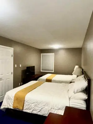 a hotel room with two beds and a television at Rainbow INN in Terrace