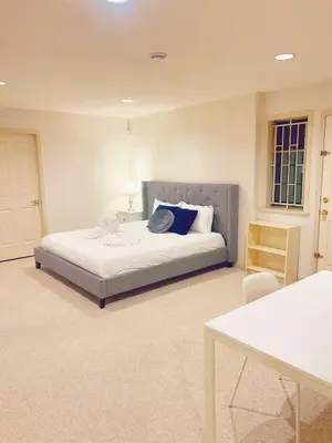 a bedroom with a large bed with blue pillows at Cozy & Modern Room near Langara & Downtown in Vancouver