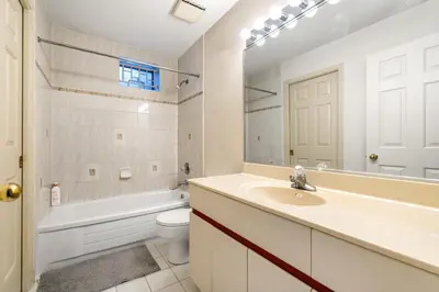 a bathroom with a sink and a toilet and a mirror at Cozy & Modern Room near Langara & Downtown in Vancouver