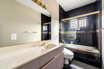 a bathroom with a sink and a toilet and a mirror at Cozy & Modern Room near Langara & Downtown in Vancouver