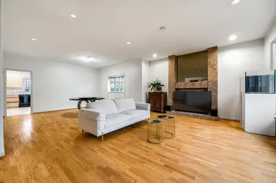 a living room with a white couch and a fireplace at Cozy & Modern Room near Langara & Downtown in Vancouver