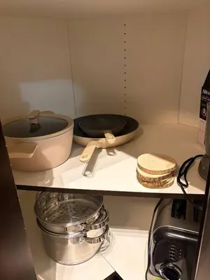 a kitchen shelf with bowls and utensils on it at Royal Bay Guest Suite in Victoria