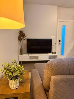 a living room with a couch and a television at Royal Bay Guest Suite in Victoria