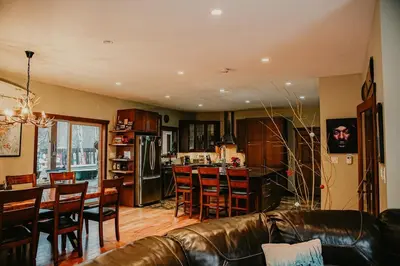 a living room with a couch and a table and a kitchen at Big Bear Chalet and spa in Revelstoke