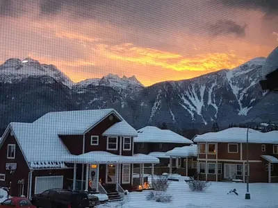 a group of houses in front of mountains with snow at Big Bear Chalet and spa in Revelstoke