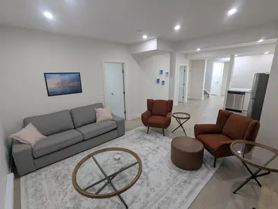 a living room with a couch and two chairs at Greystone Retreat - Walk to River & Downtown in Cochrane