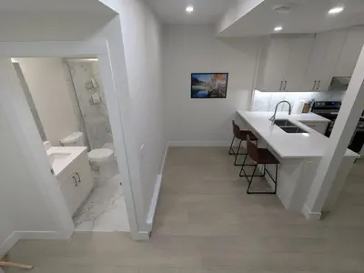 a white bathroom with a sink and a toilet at Greystone Retreat - Walk to River & Downtown in Cochrane