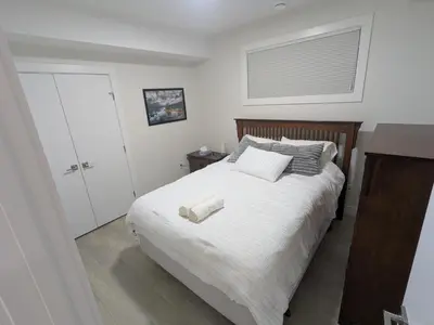 a bedroom with a bed with two towels on it at Greystone Retreat - Walk to River & Downtown in Cochrane