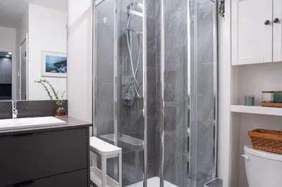 a shower with a glass door in a bathroom at Tu Casa - 2 Bedroom Condo with Private Hot tub in Revelstoke