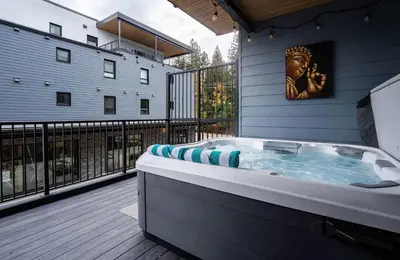 a jacuzzi tub on a balcony of a building at Tu Casa - 2 Bedroom Condo with Private Hot tub in Revelstoke