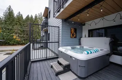 a hot tub on the deck of a house at Tu Casa - 2 Bedroom Condo with Private Hot tub in Revelstoke