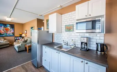 a kitchen with a sink and a refrigerator at Aurora Bayside Inn in Yellowknife
