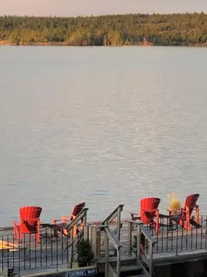a group of chairs sitting on a dock on a lake at Aurora Bayside Inn in Yellowknife
