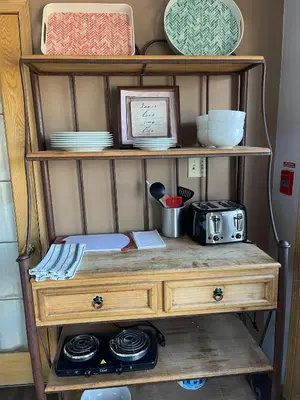 a wooden shelf with plates and dishes on it at Aurora Bayside Inn in Yellowknife