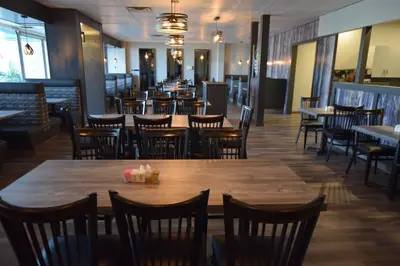 a dining room with wooden tables and chairs at Lakeland Inn Hotel in Cold Lake