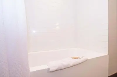 a white bath tub with a white towel on it at Sandman Hotel Abbotsford Airport in Abbotsford