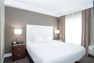 a bedroom with a large white bed and a window at Sandman Hotel Abbotsford Airport in Abbotsford