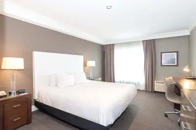 a hotel room with a white bed and a desk and a desk at Sandman Hotel Abbotsford Airport in Abbotsford