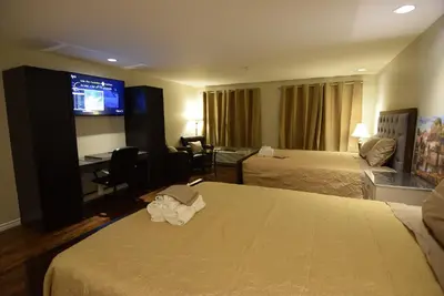 a hotel room with two beds and a flat screen tv at The Lion Inn & Suites in Chetwynd