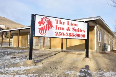 a sign for the lion inn and suites in front of a building at The Lion Inn & Suites in Chetwynd