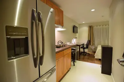a kitchen with a stainless steel refrigerator and a dining room at The Lion Inn & Suites in Chetwynd
