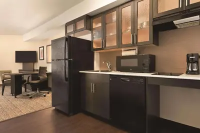 a kitchen with a black refrigerator and a desk at Park Inn by Radisson, Calgary Airport North, AB in Calgary