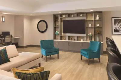 a living room with a couch and chairs and a television at Park Inn by Radisson, Calgary Airport North, AB in Calgary