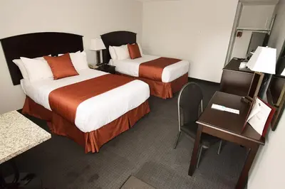 a hotel room with two beds and a desk at El Lobo Motel in Cold Lake