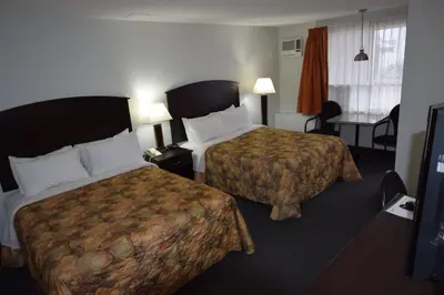 a hotel room with two beds and a table at El Lobo Motel in Cold Lake