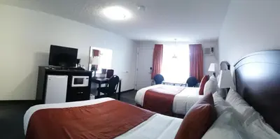 a hotel room with two beds and a flat screen tv at El Lobo Motel in Cold Lake