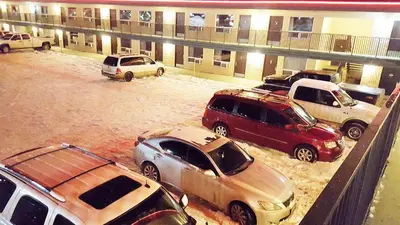 a group of cars parked in a parking lot at Westport Inn in Grande Prairie