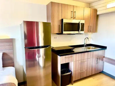 a kitchen with a stainless steel refrigerator and a sink at Westport Inn in Grande Prairie