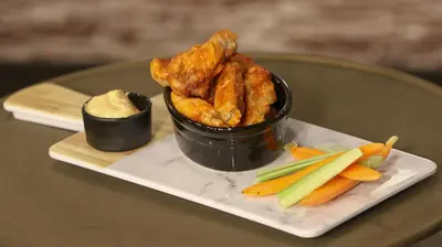 a plate of food with chicken and vegetables on a table at Microtel Inn & Suites by Wyndham Bonnyville in Bonnyville