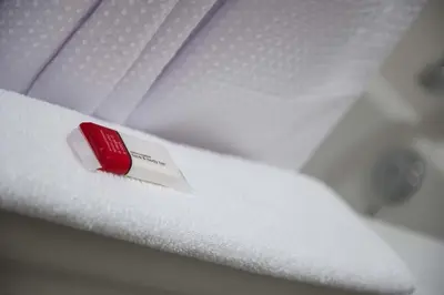 a red wrapper on top of a pile of white towels at Microtel Inn & Suites by Wyndham Bonnyville in Bonnyville